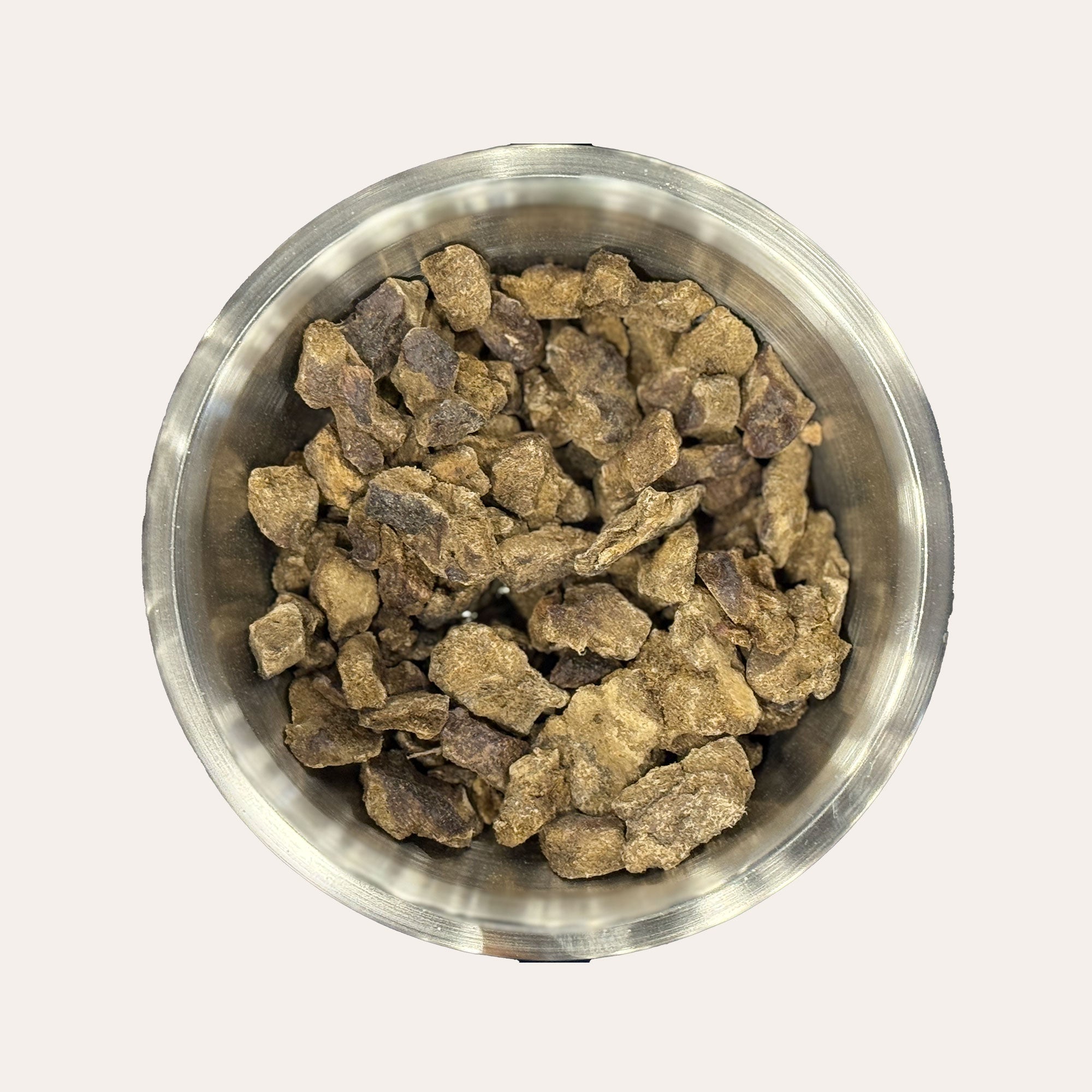 Metal bowl filled with Ernie's Positively Good freeze-dried beef liver dog treats.