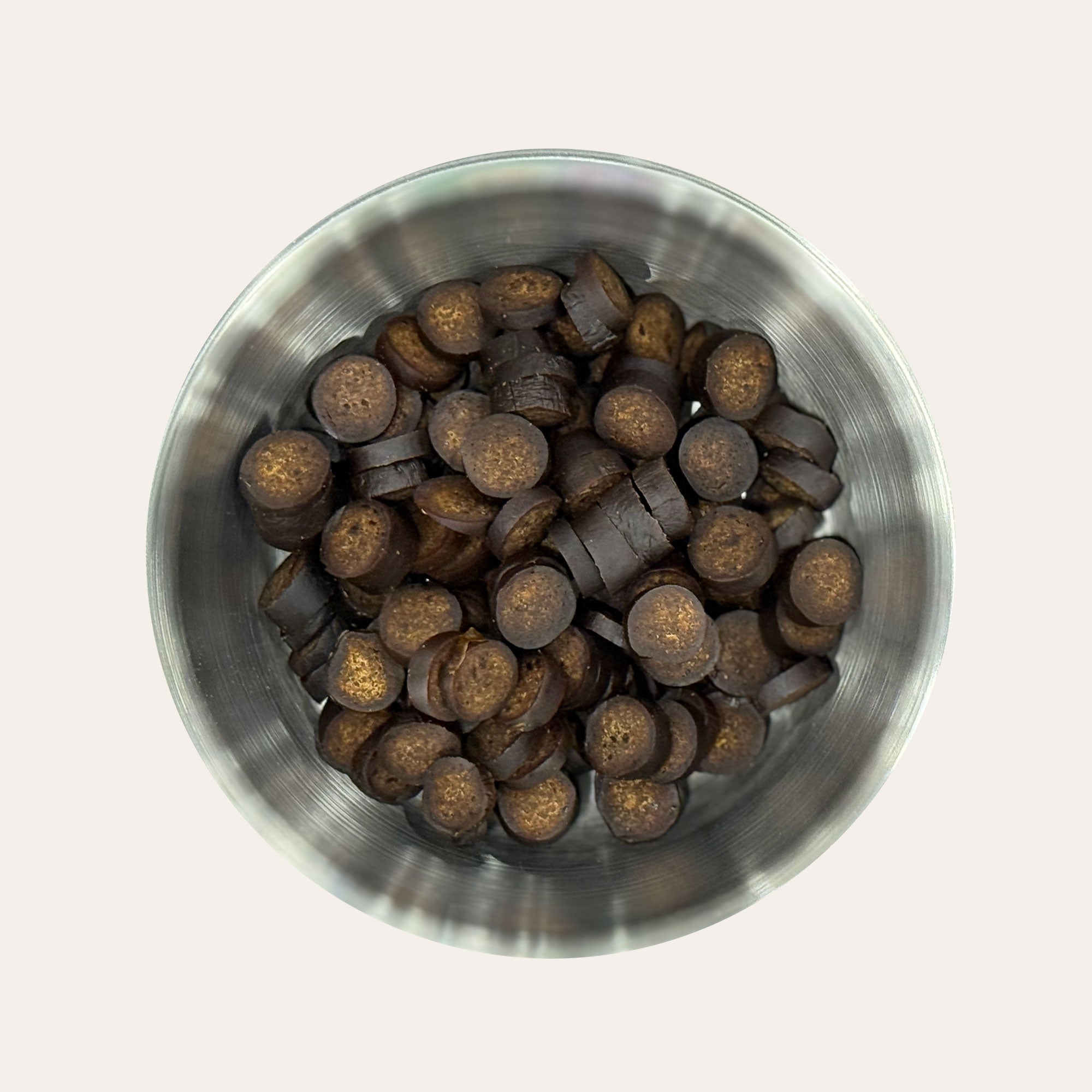 Metal bowl filled with Ernie's Ostrich Bites dog treats.